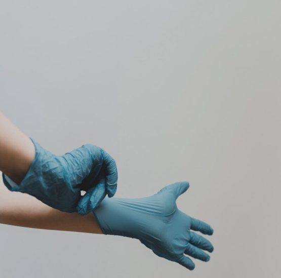 person putting on blue medical gloves