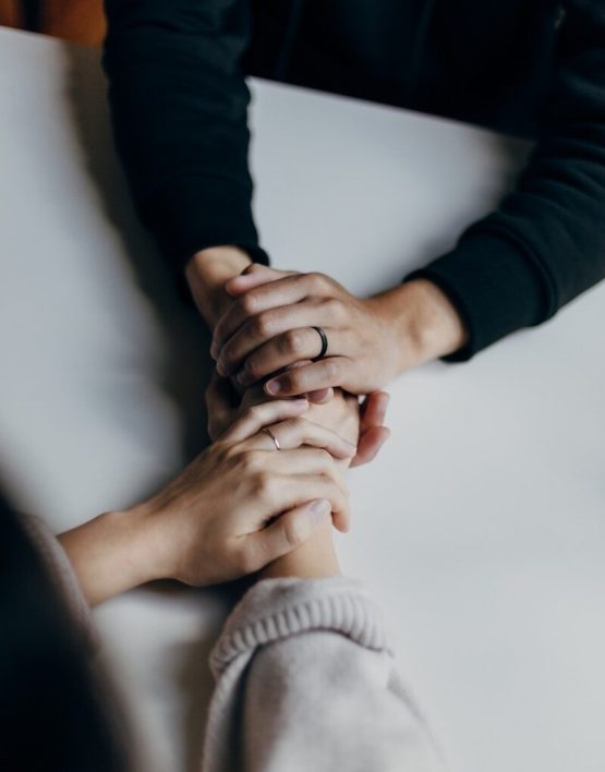 two people holding hands on table in comfort
