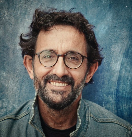 man in gray denim jacket wearing black framed eyeglasses