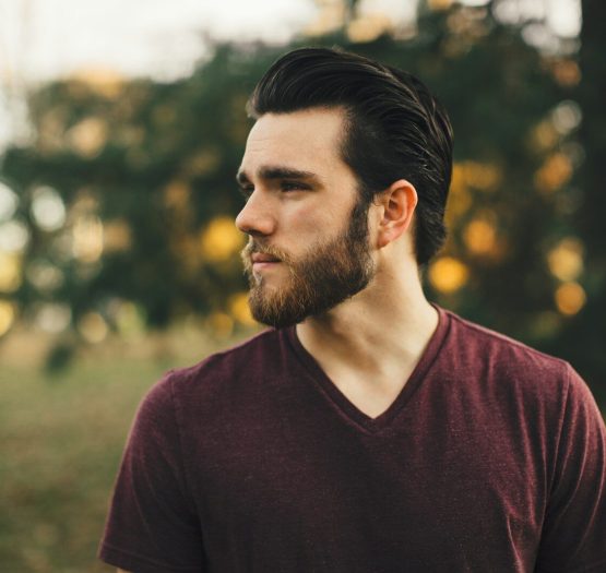 Photo by Drew man wearing maroon V-neck t-shirt in forest