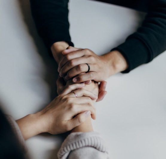 Photo by Priscilla Du Preez 🇨🇦 two people holding hands on table in comfort