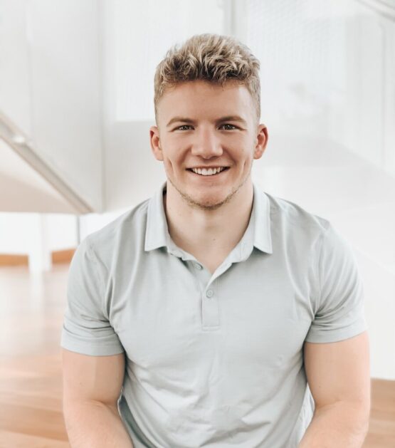Photo by Derick McKinney man in gray polo shirt smiling