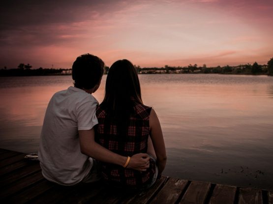 man and woman sitting on dock