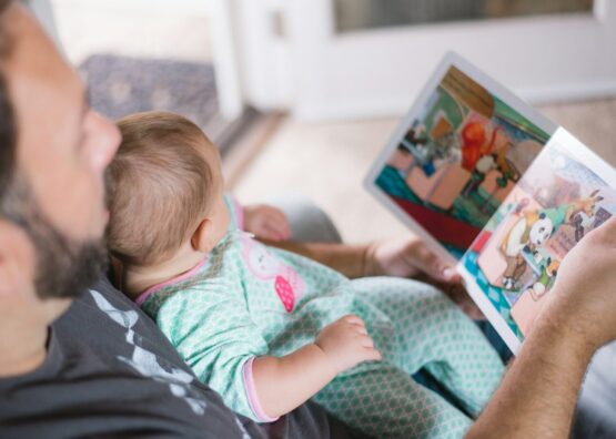 Photo by Picsea person carrying baby while reading book