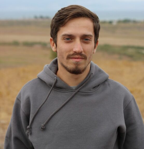 man in gray hoodie standing on field during daytime